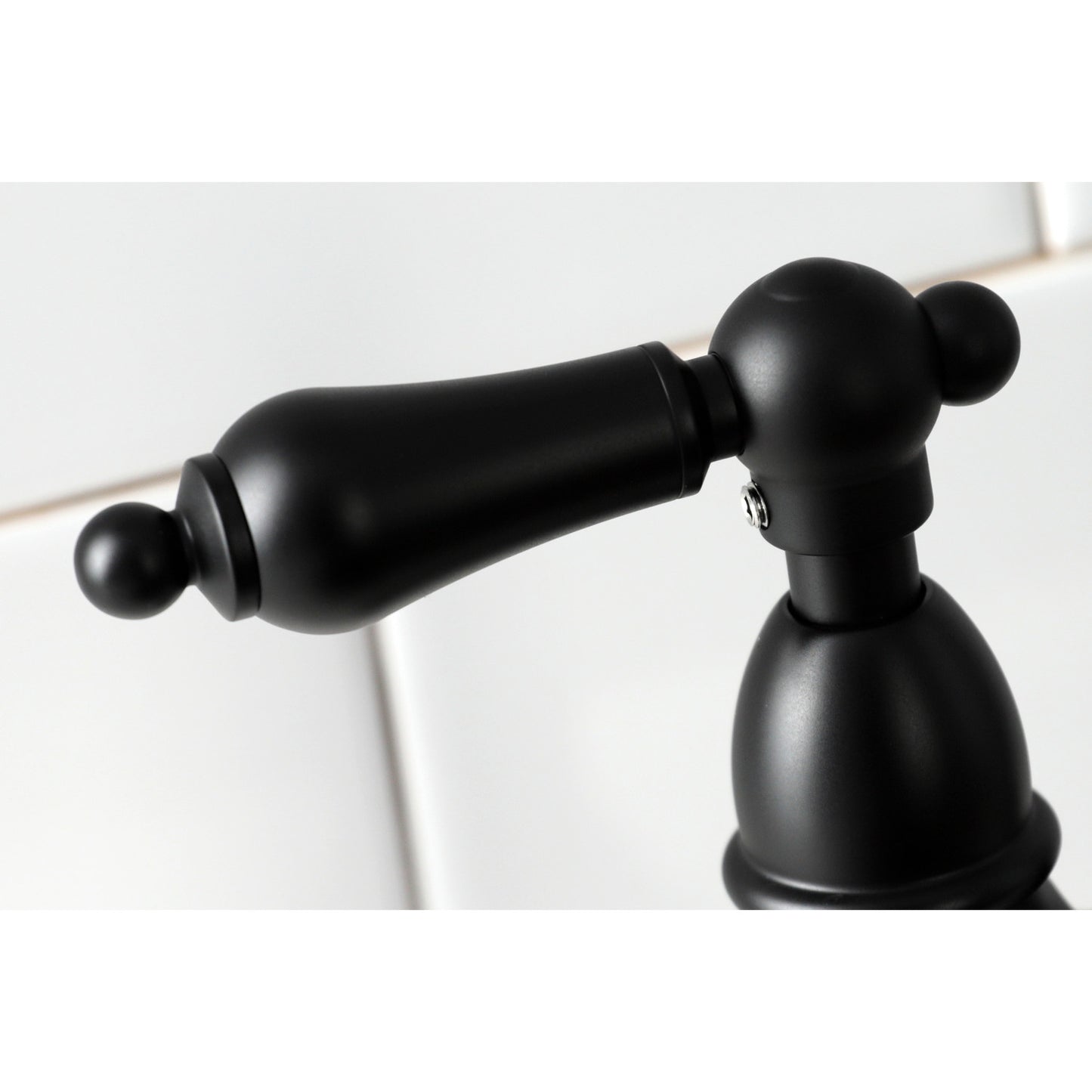 KINGSTON Brass Heritage Bridge Kitchen Faucet with Brass Sprayer close-up view of the handle design.