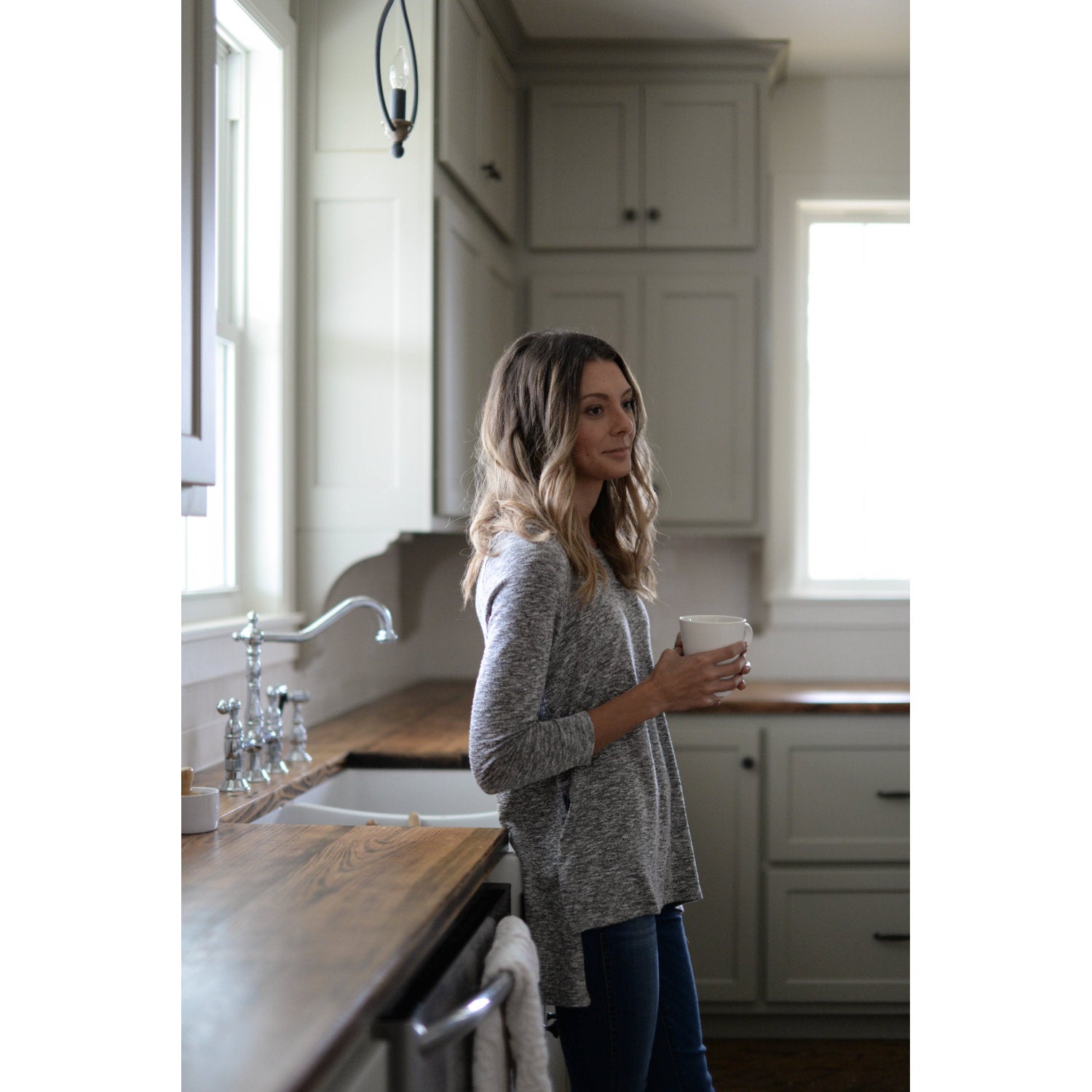 Kingston Brass KS1271ALBS  kitchen faucet in a ktichen setting with woman leaning against the sink
