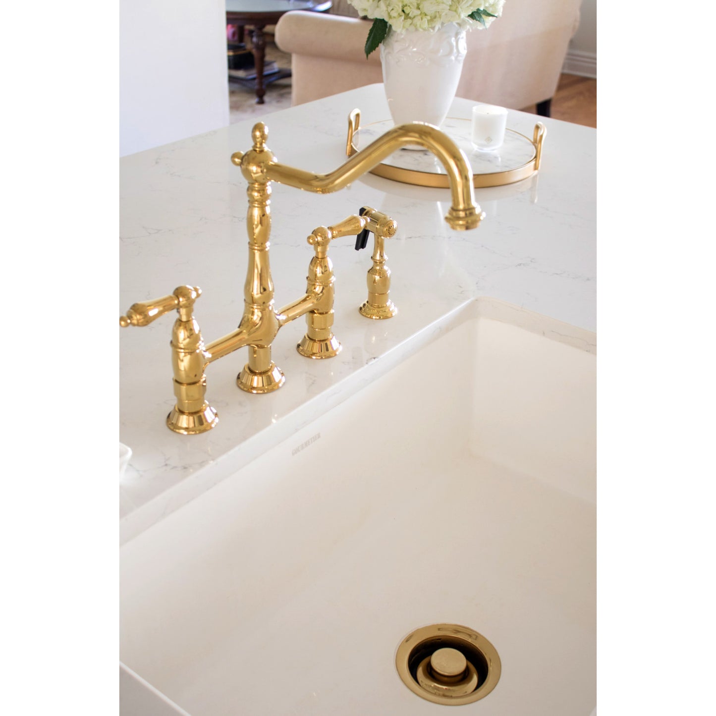 Kingston Brass KS1272ALBS polished brass kitchen faucet on a white sink in a kitchen setting