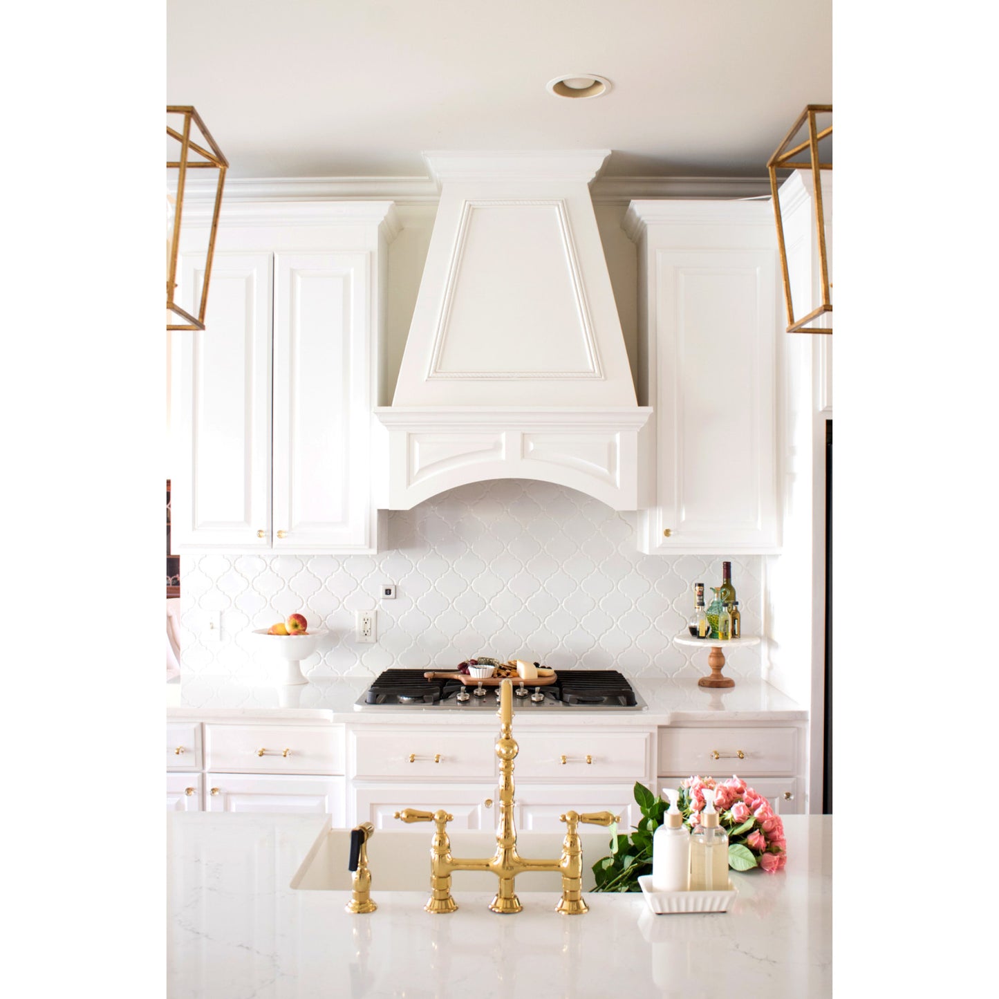 Elegant kitchen with KINGSTON Brass Heritage Bridge Kitchen Faucet with Brass Sprayer and white cabinetry.