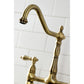 Kingston Brass KS1273ALBS antique brass kitchen faucet head detail against a white tiled wall