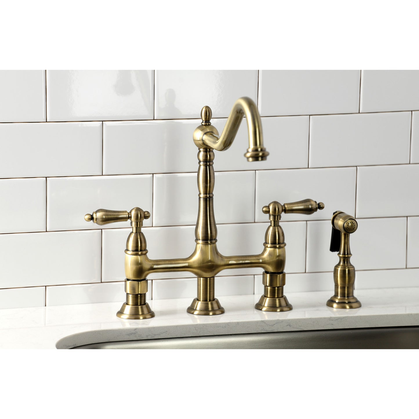 KINGSTON Brass Heritage Bridge Kitchen Faucet with Brass Sprayer right side view against white tile background.
