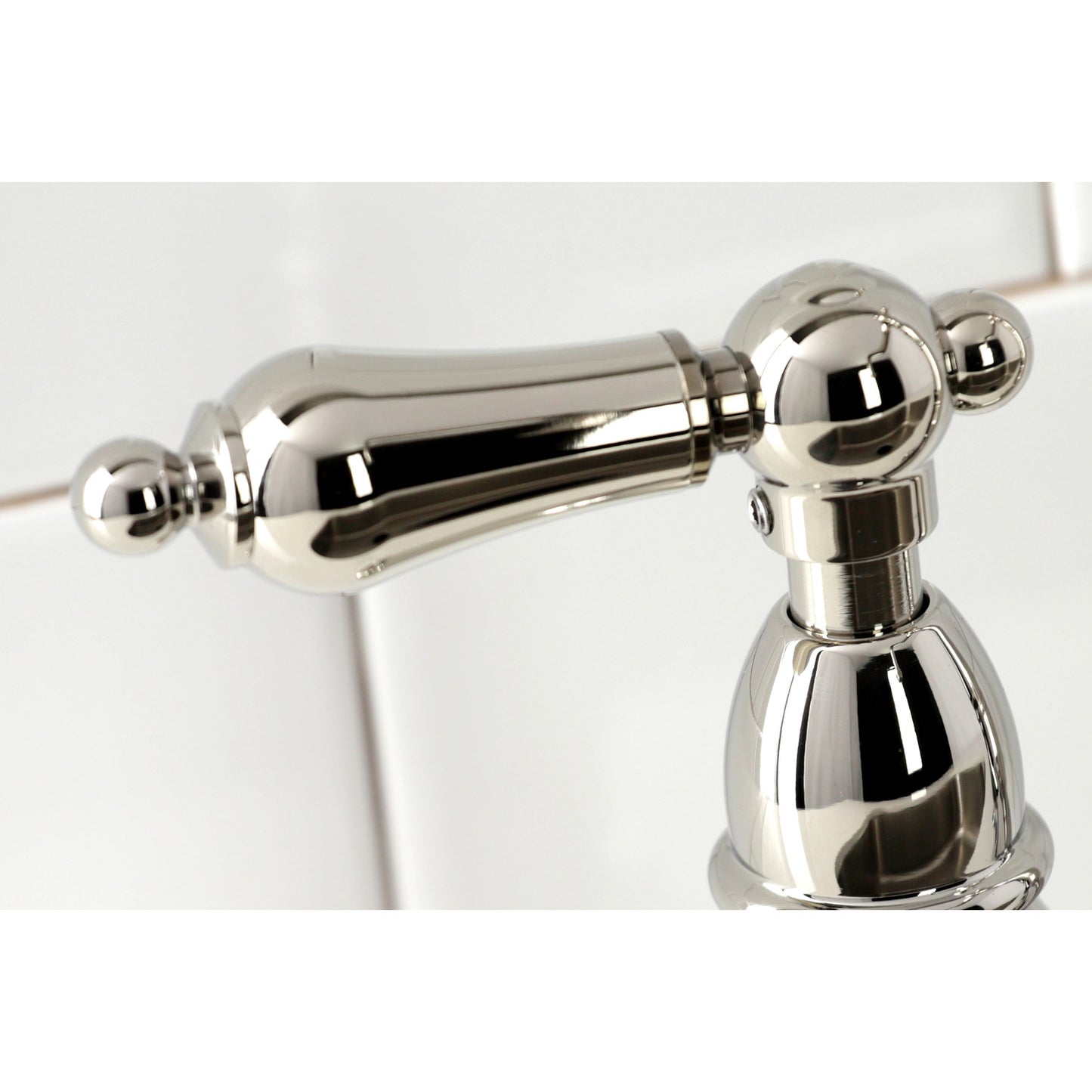 Close-up of handle on KINGSTON Brass Heritage Bridge Kitchen Faucet with Brass Sprayer, highlighting Victorian-inspired design.