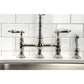 Kingston Brass KS1276ALBS polished nickel bridge faucet with handles on a kitchen sink against a white tiled wall.
