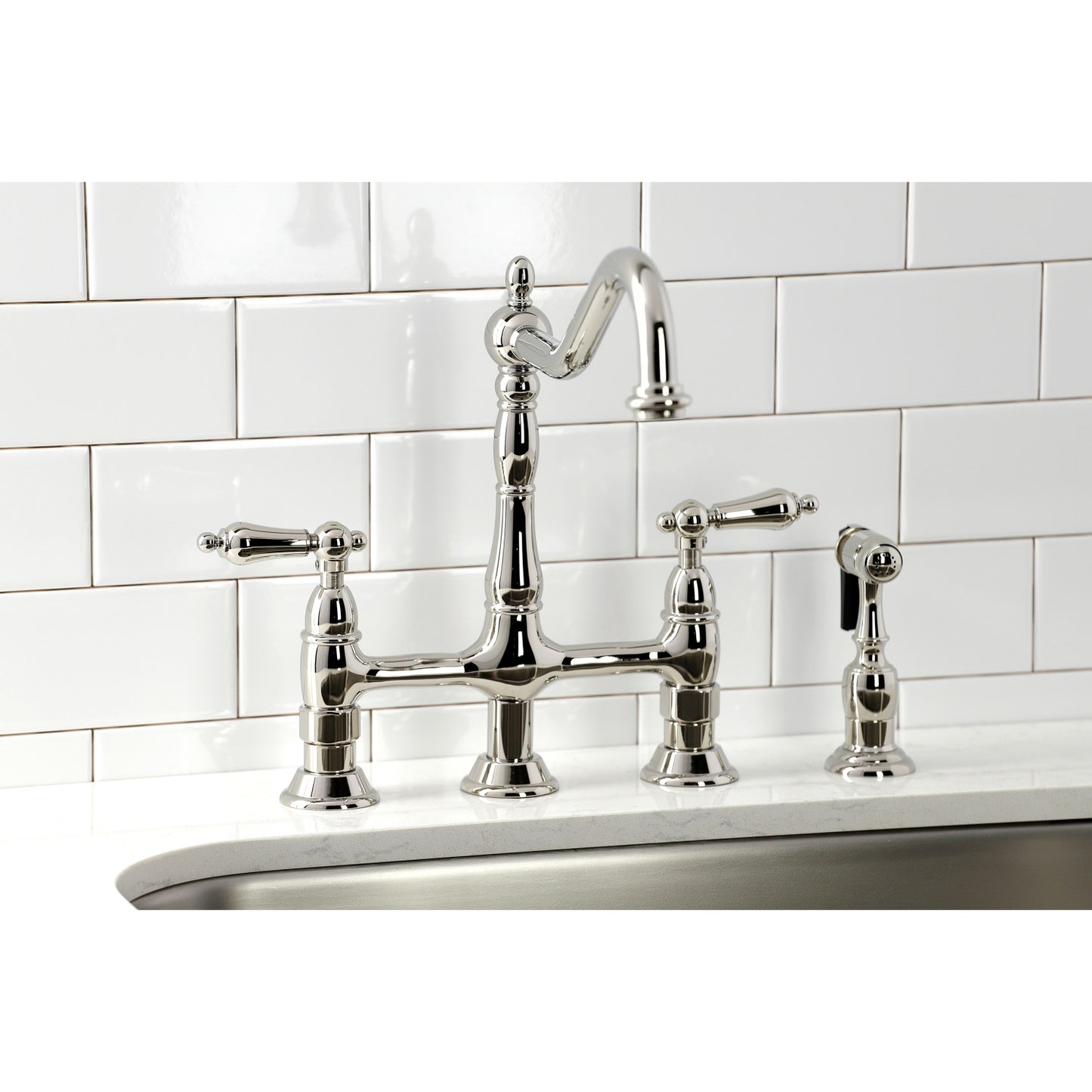 Close-up view of KINGSTON Brass Heritage Bridge Kitchen Faucet with Brass Sprayer on white tiled background.