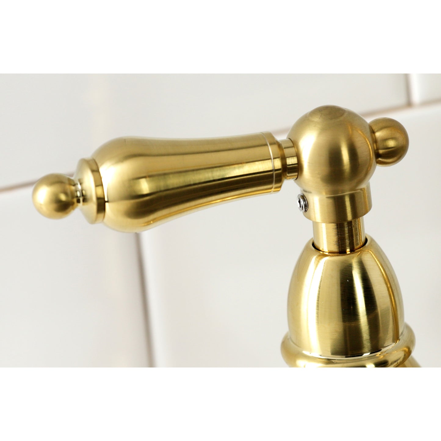 Close-up view of the handle on the KINGSTON Brass Heritage Bridge Kitchen Faucet with Brass Sprayer.