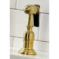 Close up of Kingston Brass KS1277ALBS brushed brass kitchen faucet sprayer on a white tiled background