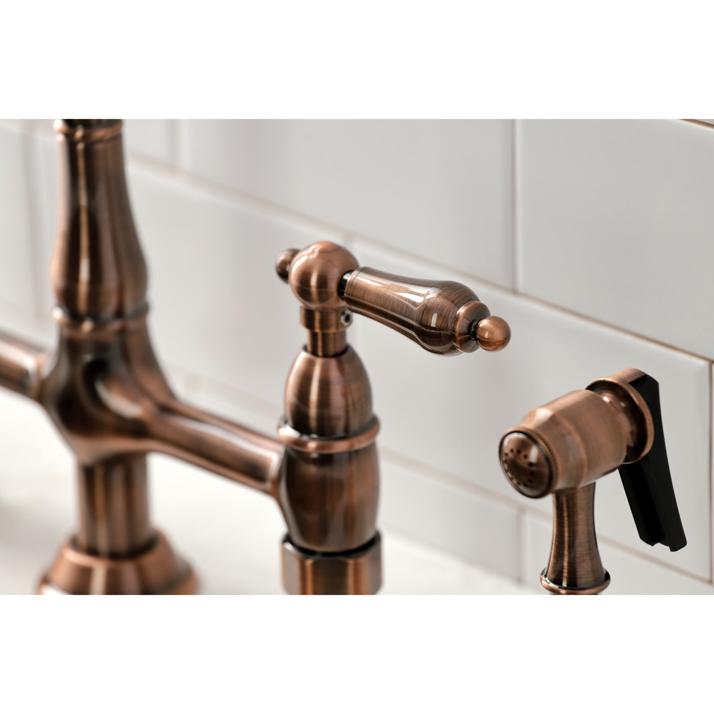Close-up of the KINGSTON Brass Heritage Bridge Kitchen Faucet with Brass Sprayer showing elegant handle design.