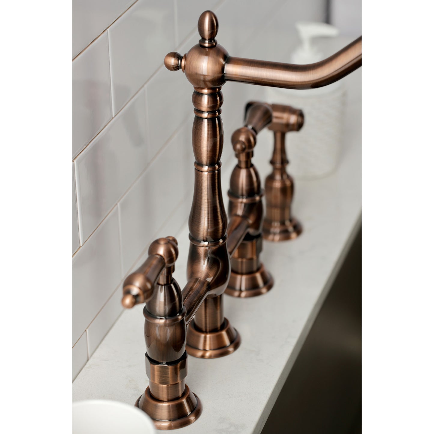 Side view of Kingston Brass KS127ALBSAC antique copper kitchen bridge faucet with side spray