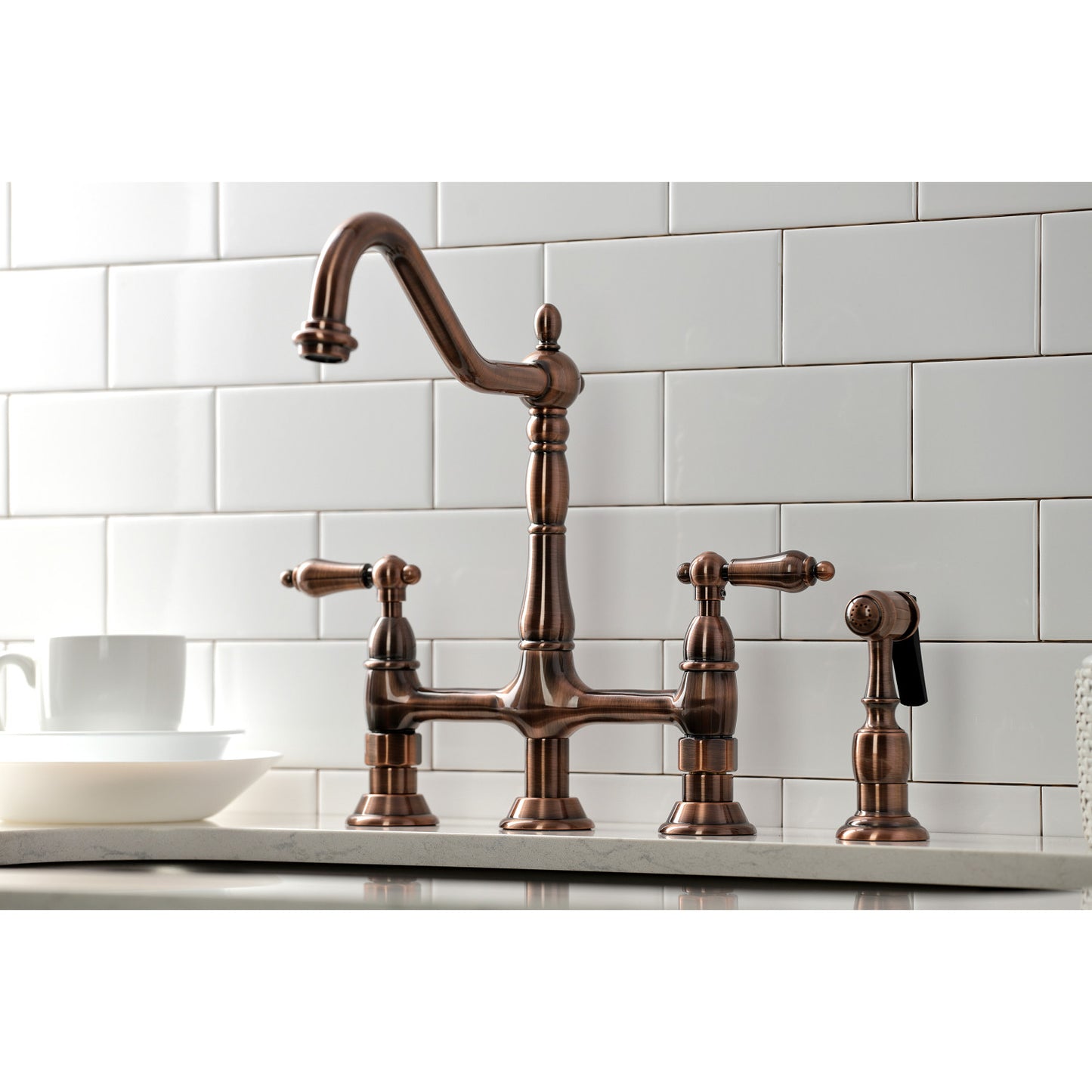 Kingston Brass KS127ALBSAC antique copper vintage style kitchen bridge faucet set against a white tiled wall