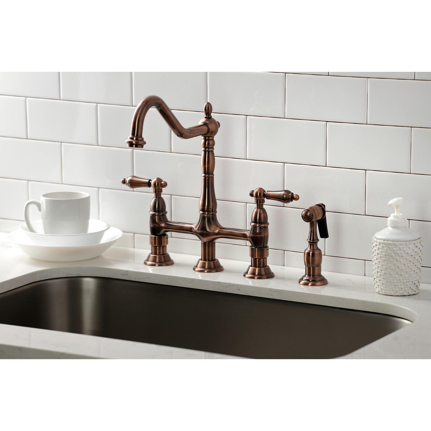 KINGSTON Brass Heritage Bridge Kitchen Faucet with Brass Sprayer in a kitchen setting, right side view with dishes.