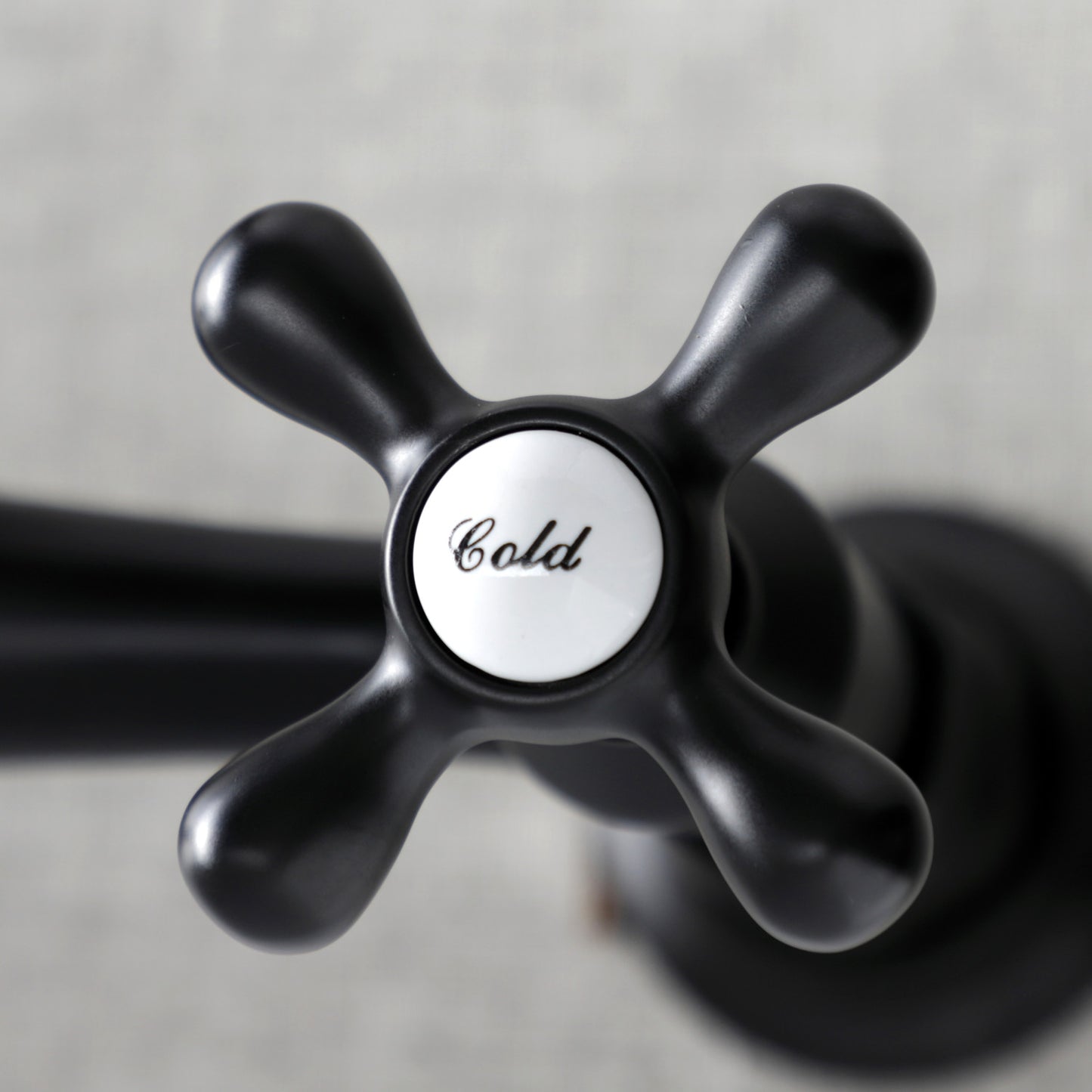 Kingston Brass KS3240AX matte black bathroom faucet handle with 'Cold' label on a neutral background