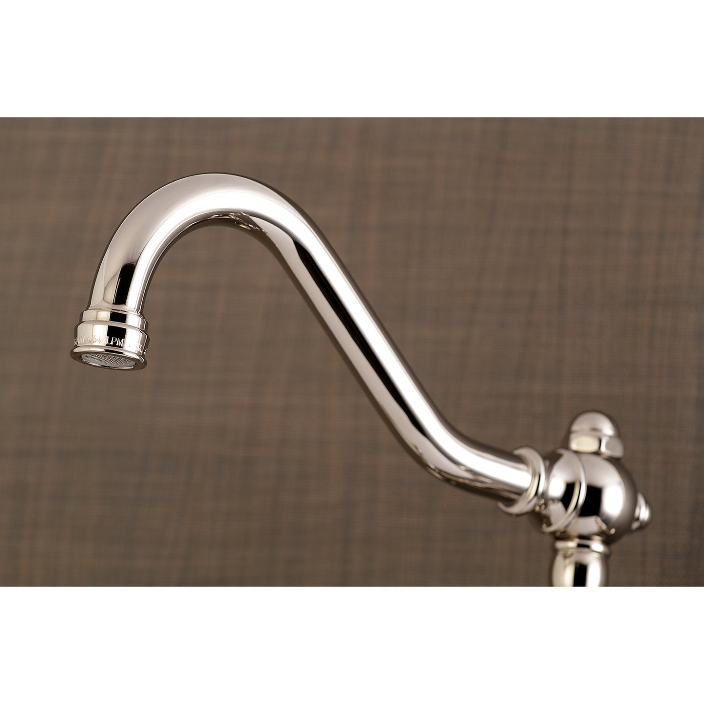 Close-up view of the spout of KINGSTON Brass Vintage Wall Mount Bathroom Faucet - KS3245AX showcasing its elegant curvature.