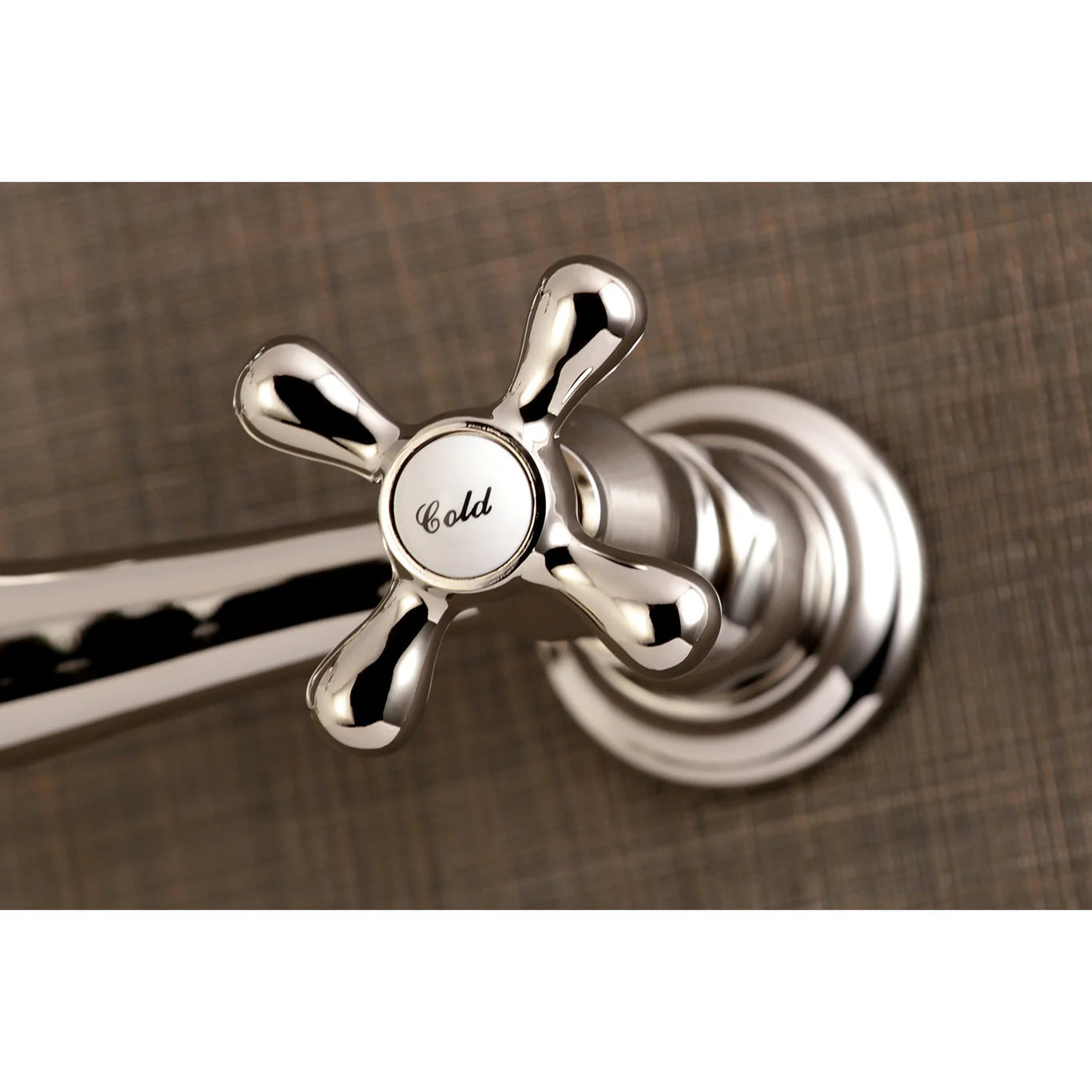 Kingston Brass KS3246AX Polished Nickel  faucet handle with 'Cold' indicator on a brown textured background