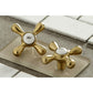 Kingston Brass KS3237AX brushed brass bathroom faucet handle samples on a tiled surface