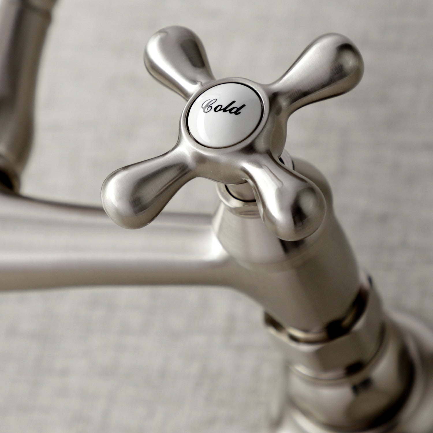 Close-up of Kingston Brass KS3248AX brushed nickel faucet handle with 'Cold' label on a neutral background