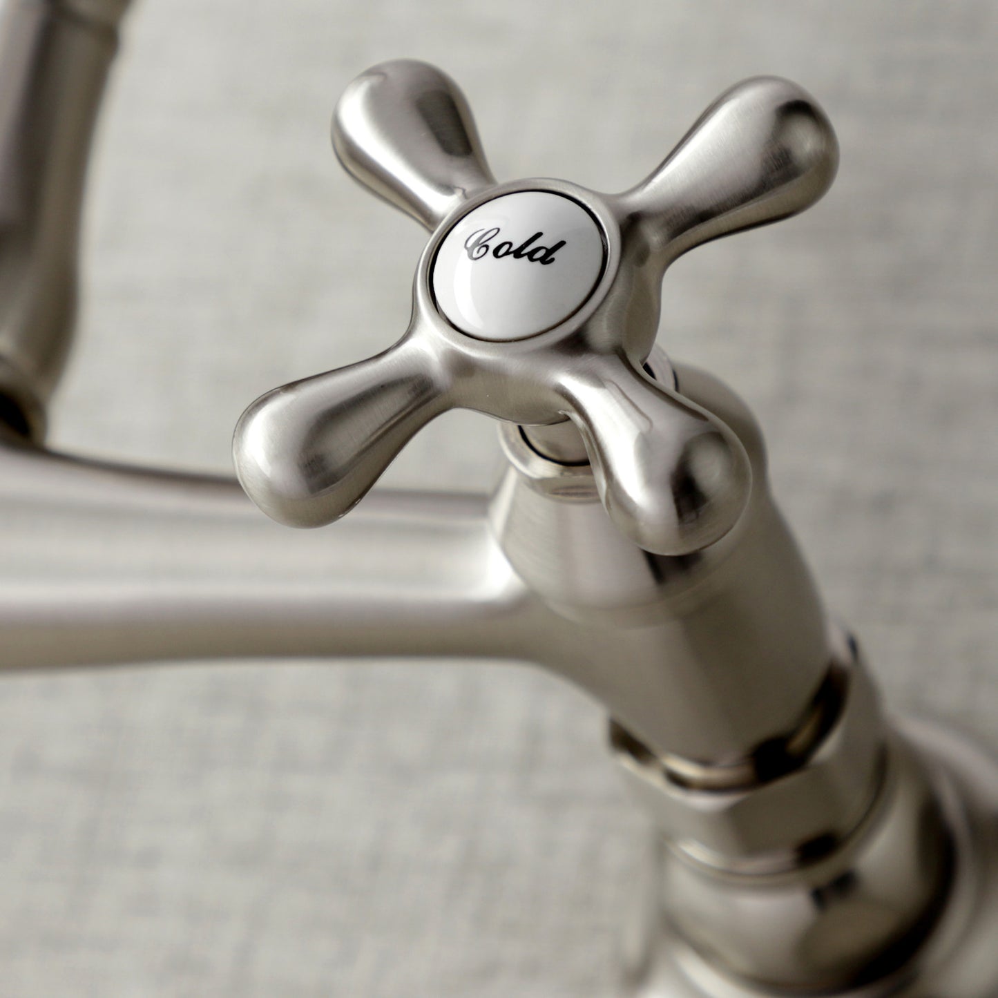 Close-up of Kingston Brass KS3248AX brushed nickel faucet handle with 'Cold' label on a neutral background