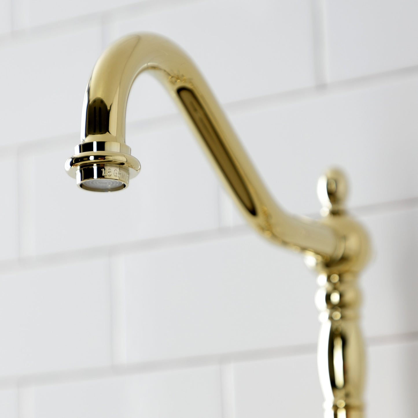 Kingston Brass English Country Deck Mount Bridge Kitchen Faucet close-up of spout design against white backsplash