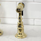 Kingston Brass KS7752AXBS polished brass side spray faucet against a white tiled wall