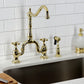Kingston Brass KS7752AXBS polished brass faucet set on a kitchen sink with white tiled wall background
