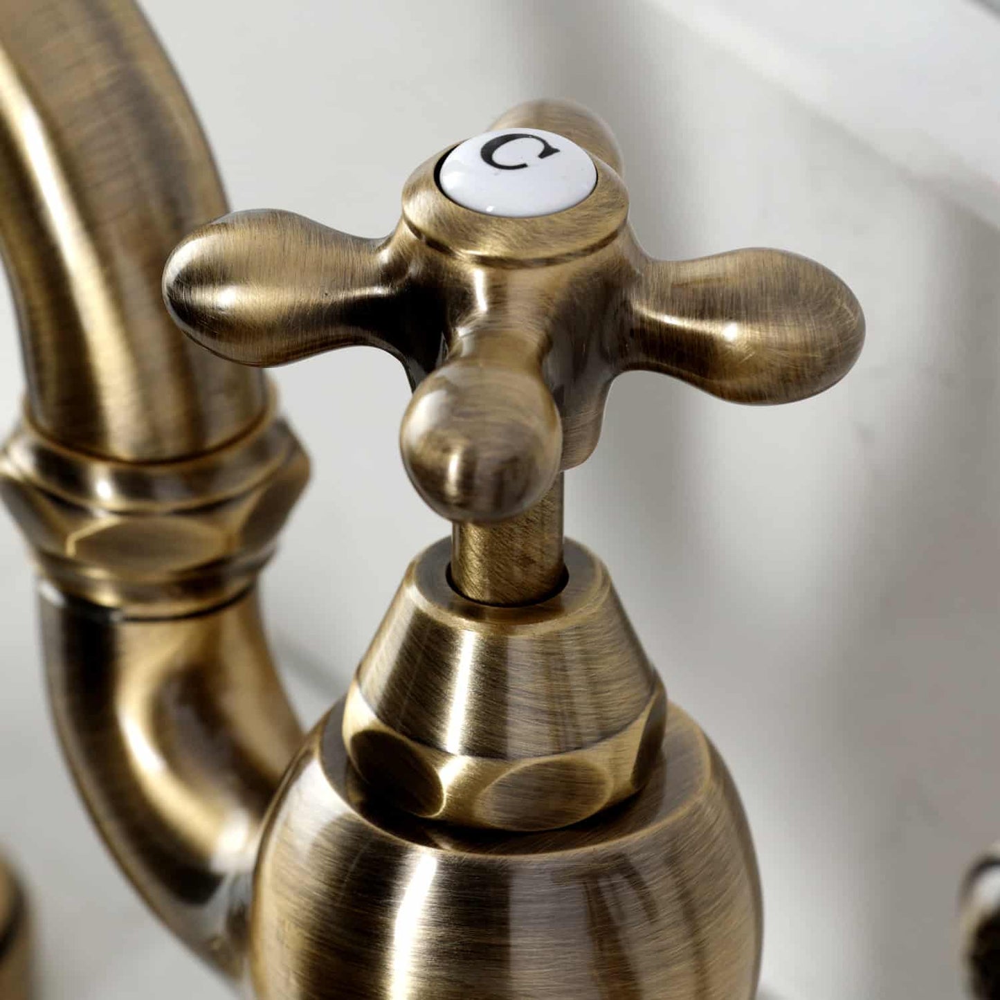 Close-up of the handle on Kingston Brass English Country Deck Mount Bridge Kitchen Faucet showcasing its elegant design.