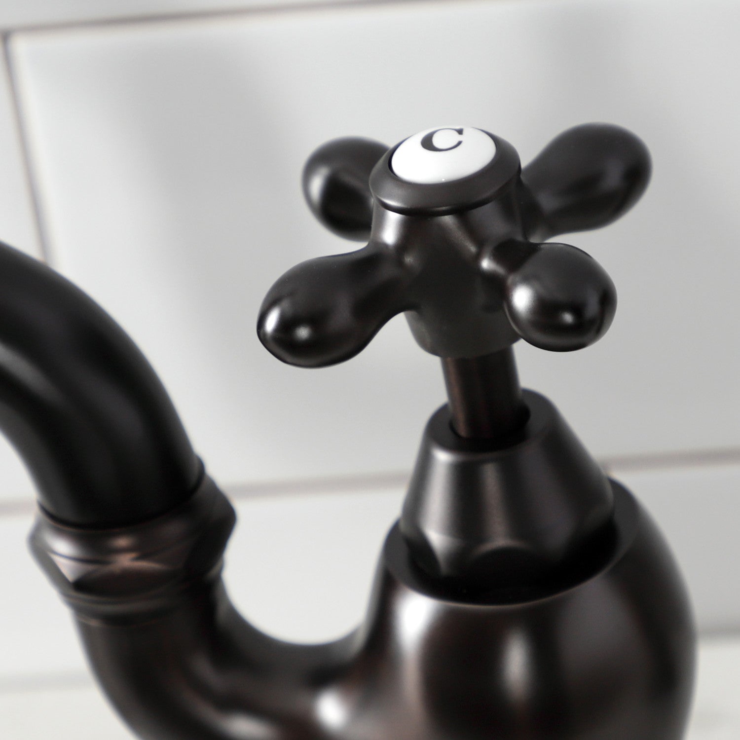 Close-up of Kingston Brass KS7755AXBS oil rubbed bronze faucet handle with a white background