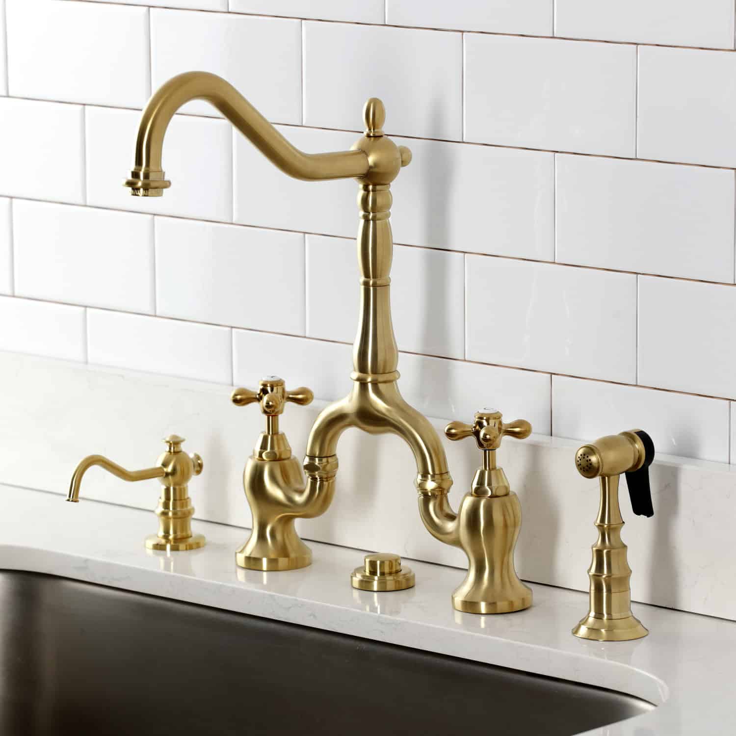 Kingston Brass KS7757AXBS Brushed Brass kitchen faucet installed on a white granite countertop