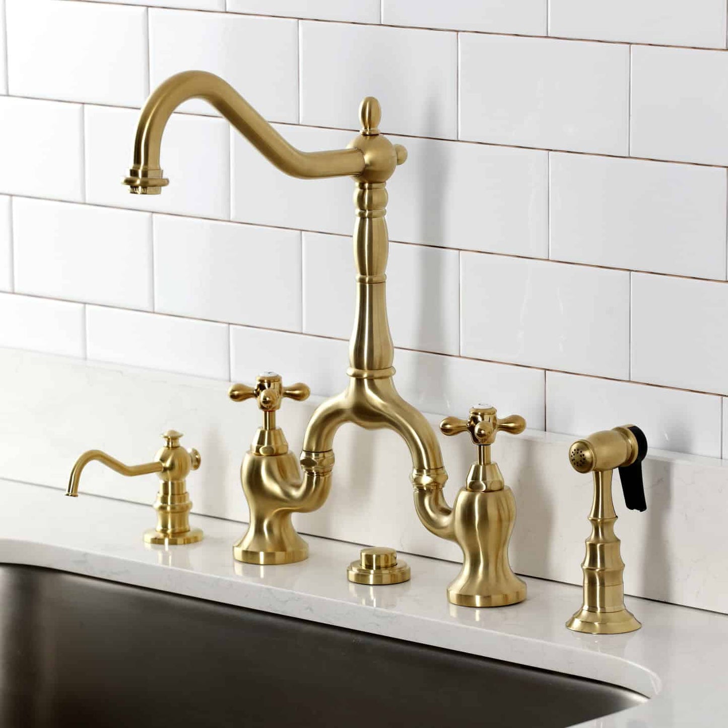 Kingston Brass KS7757AXBS Brushed Brass kitchen faucet installed on a white granite countertop