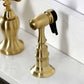 Kingston Brass KS7757AXBS Brushed Brass kitchen faucet showing side spray head on a white countertop