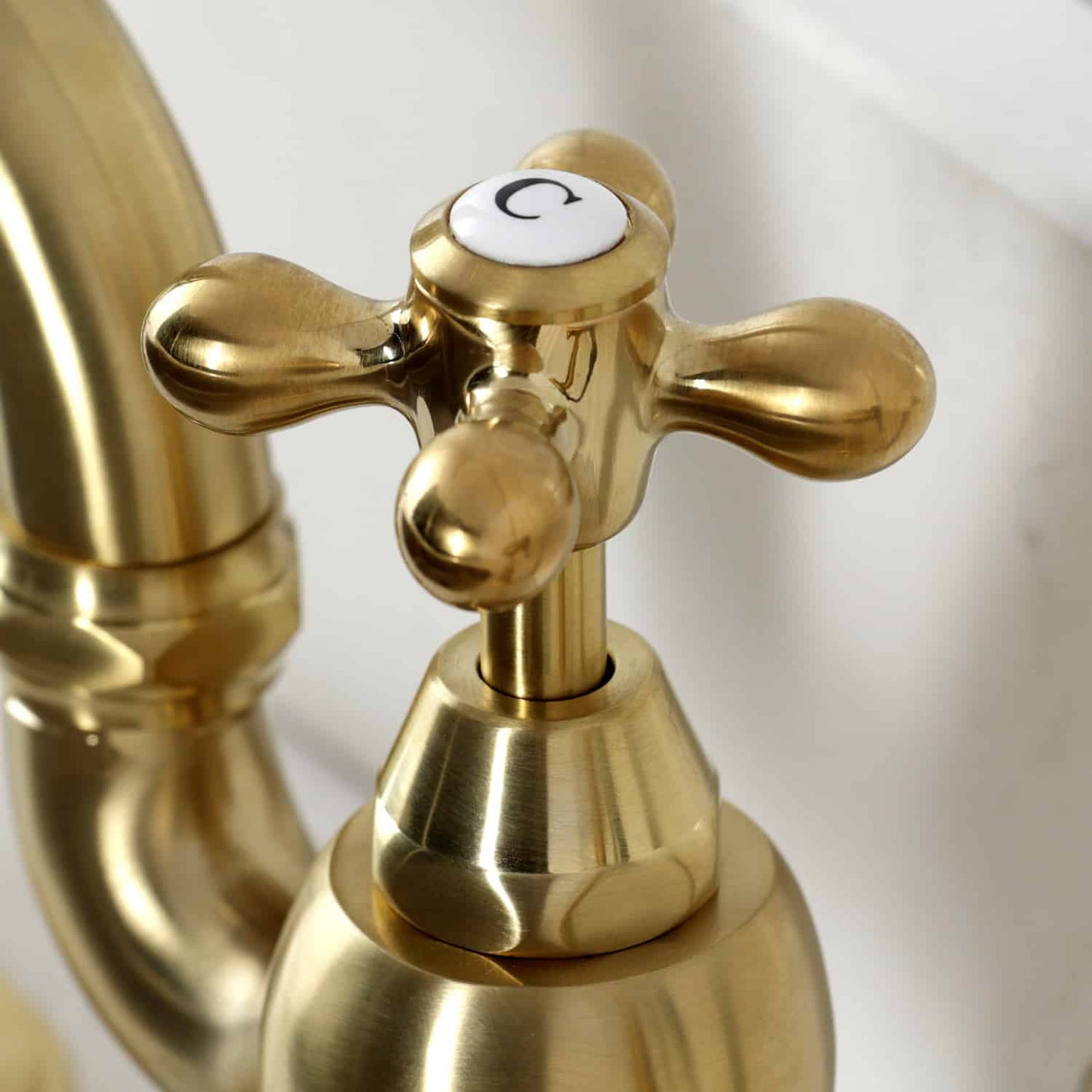 Close-up of the handle of Kingston Brass English Country Deck Mount Bridge Kitchen Faucet with a classic design.