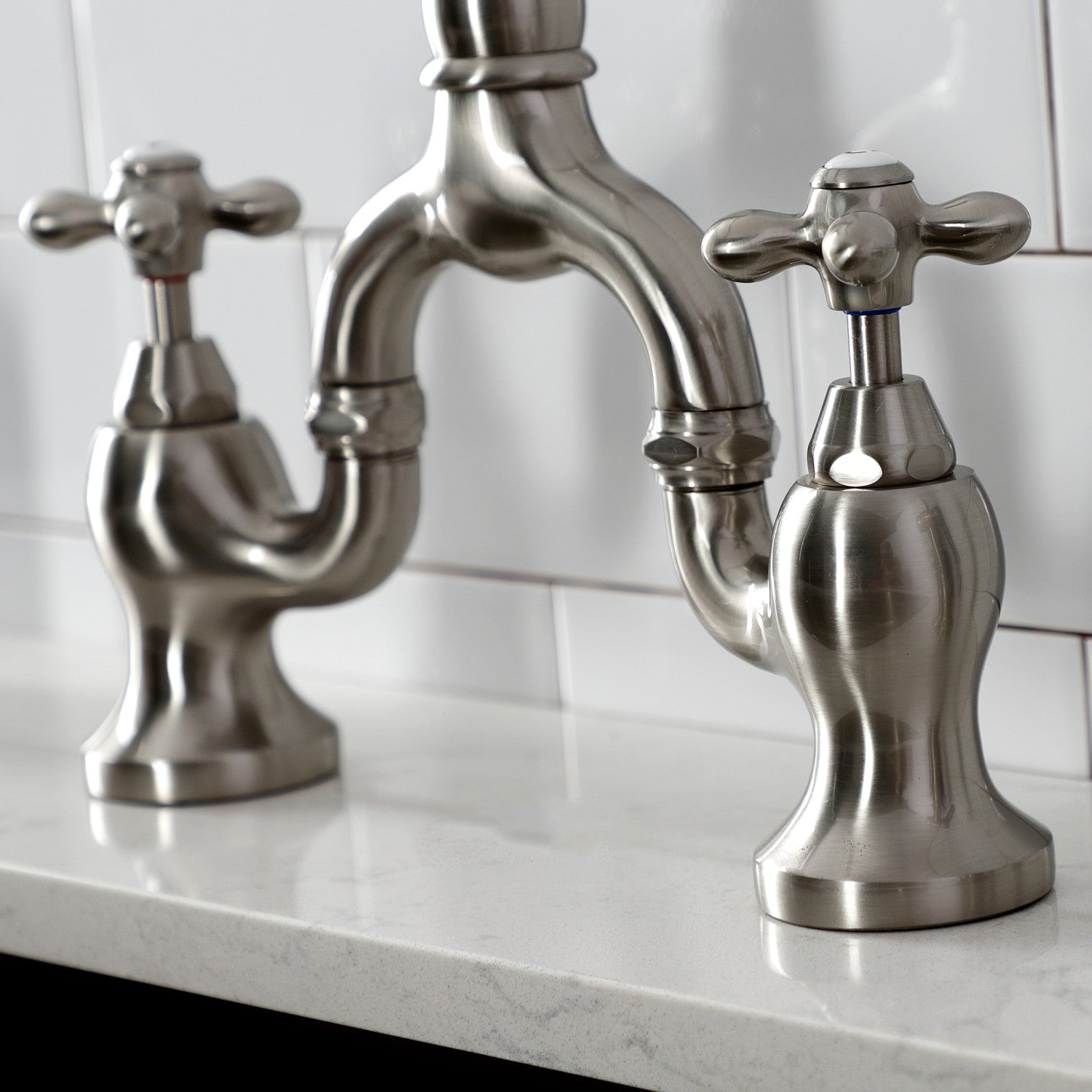 Kingston Brass KS7758AXBS brushed nickel faucet set on a white countertop with a tiled backsplash.