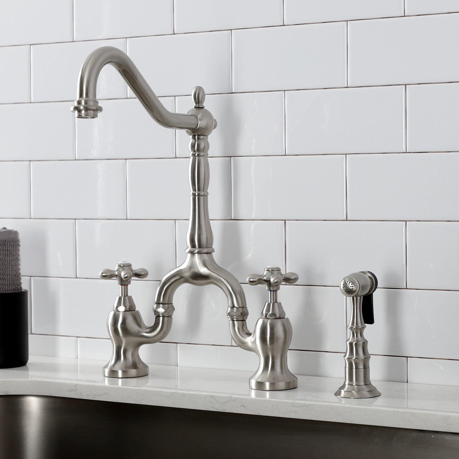 Kingston Brass KS7758AXBS brushed nickel kitchen faucet installed on a white quartz countertop
