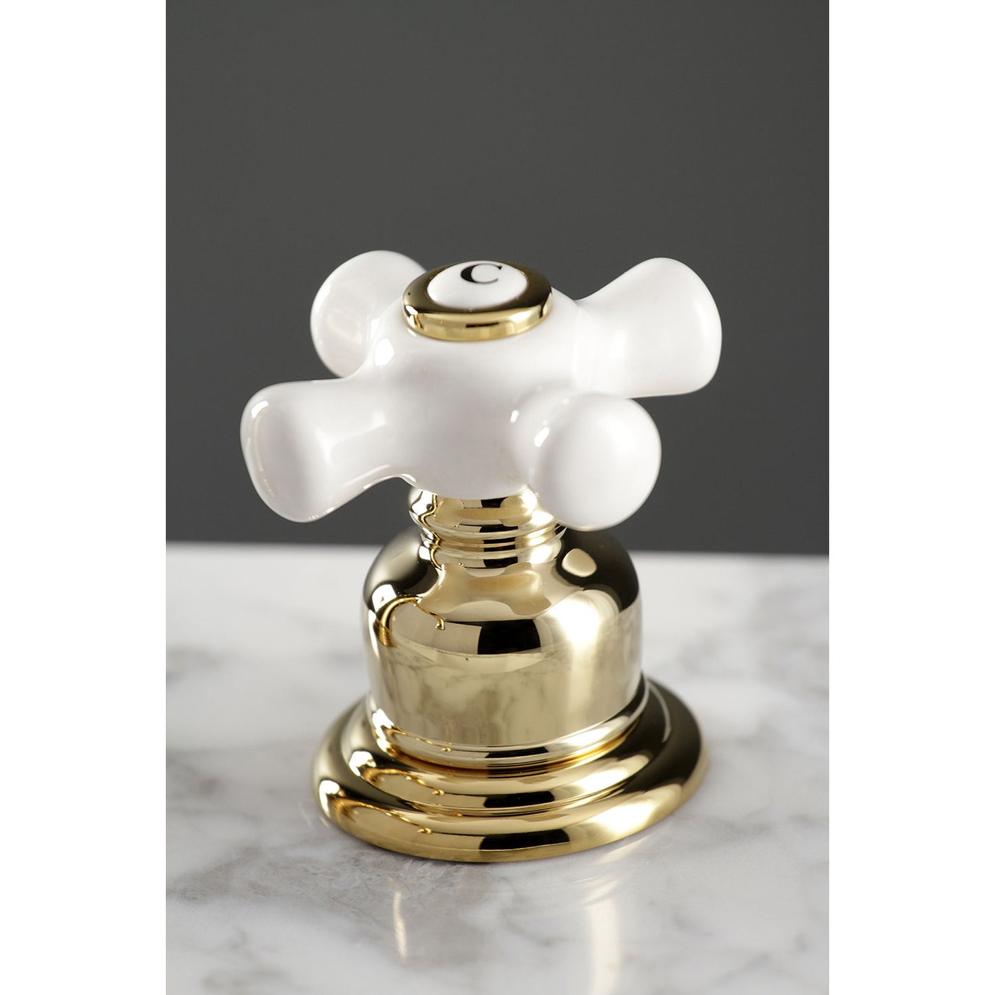 Close-up view of the KINGSTON Brass American Classic Widespread Bathroom Faucet handle showcasing Victorian design.