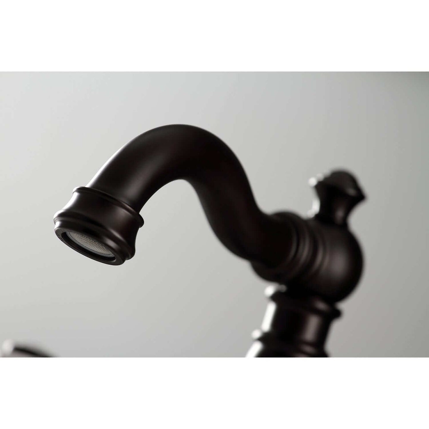 Close-up of KINGSTON Brass American Classic Widespread Bathroom Faucet spout highlighting Victorian design details.