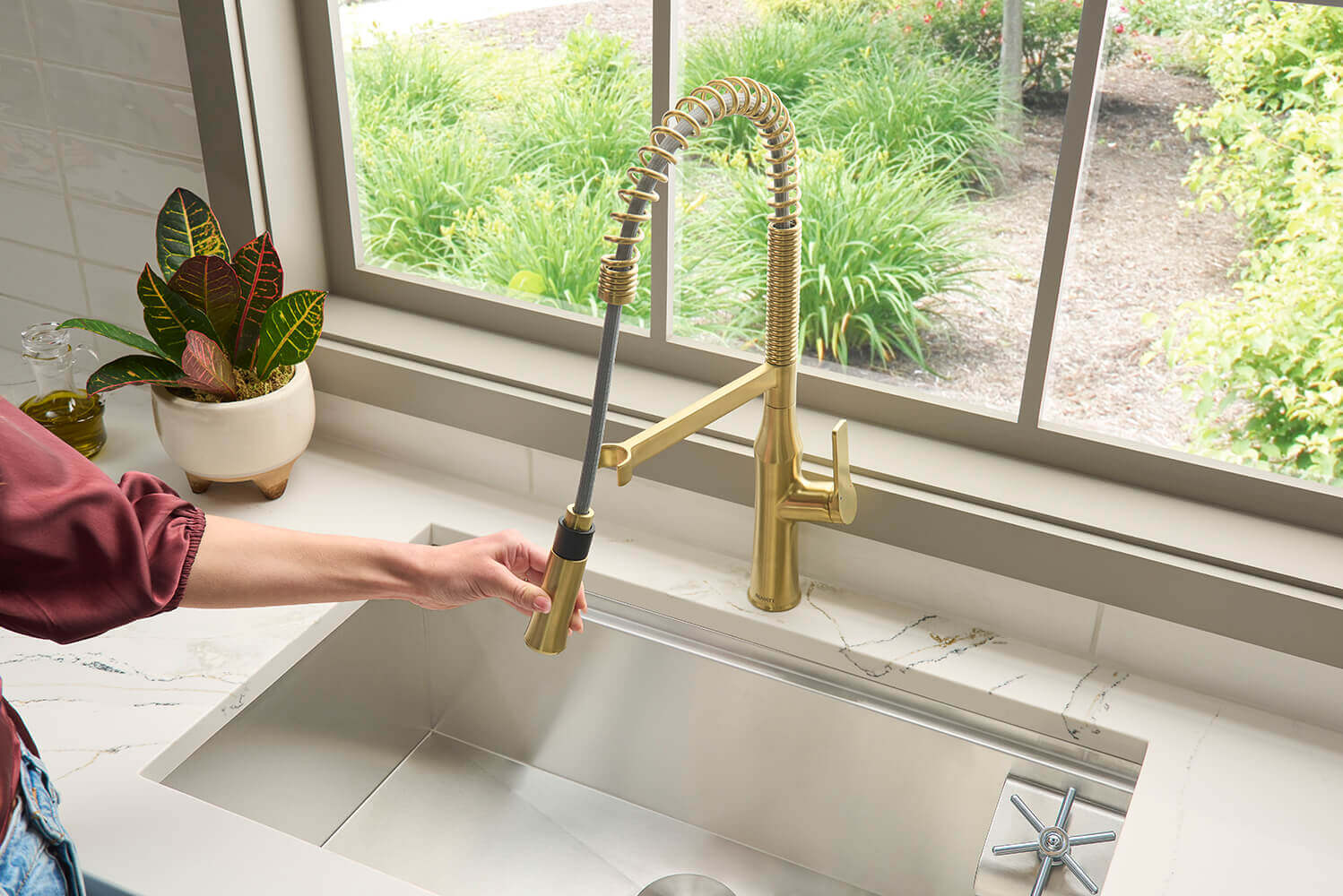 Ruvati RVF1233 Bianca Single-Handle Tall High-Arc Commercial Kitchen Faucet with Pre-Rinse Sprayer in a modern kitchen.