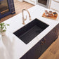 Ruvati 32" epiGranite undermount kitchen sink in Midnight Black, set in modern kitchen with white countertop and dark cabinets.
