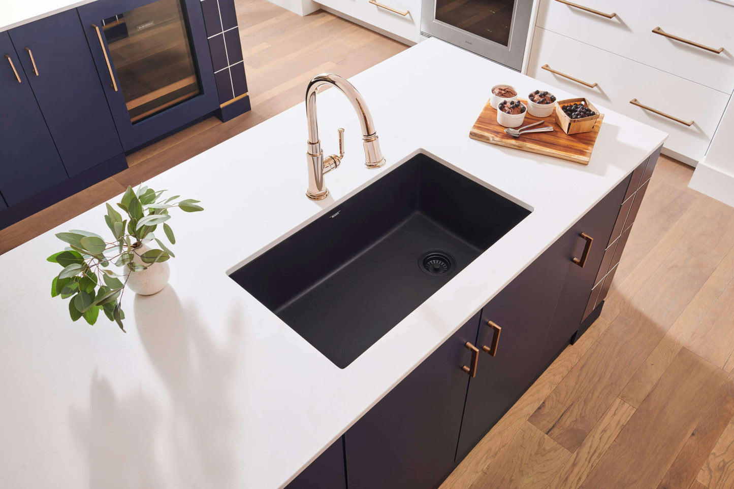 Ruvati 32" epiGranite undermount kitchen sink in Midnight Black, set in modern kitchen with white countertop and dark cabinets.