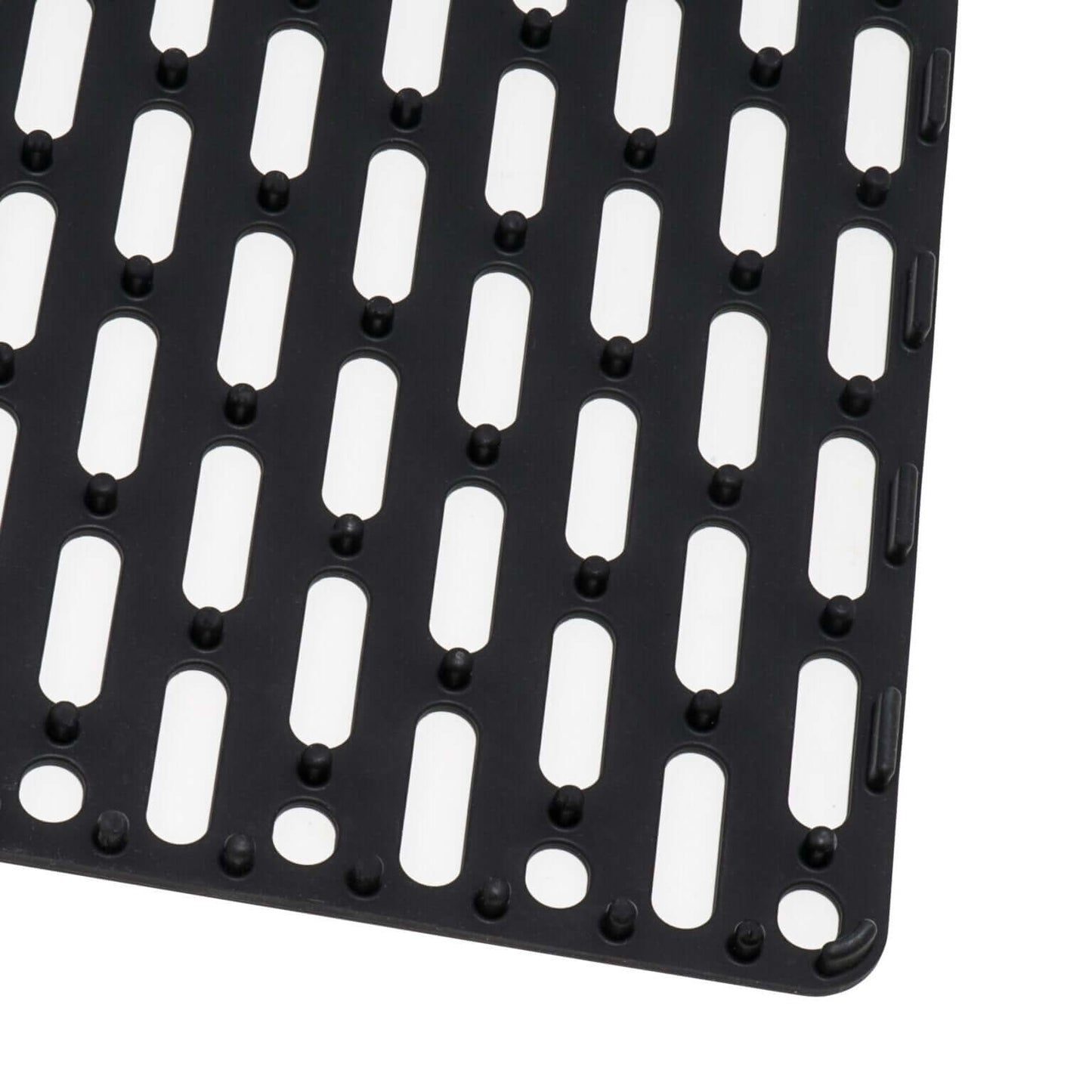Black kitchen sink mat with drainage holes and textured surface for drying dishes and protecting sink.