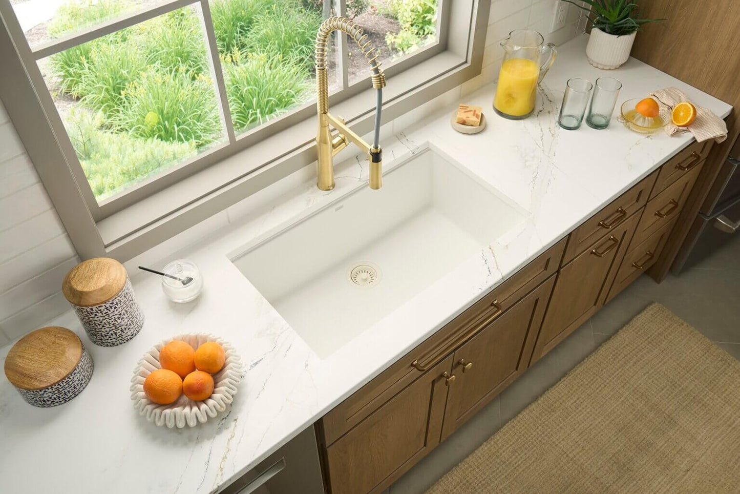 Ruvati 32" undermount epiGranit kitchen sink in marble countertop, with wooden cabinets.