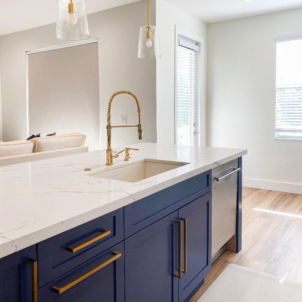 ZLINE Sierra Kitchen Faucet installed in a modern kitchen with blue cabinets and marble countertop.