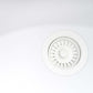 Close-up of a white kitchen sink drain in a Ruvati undermount sink.