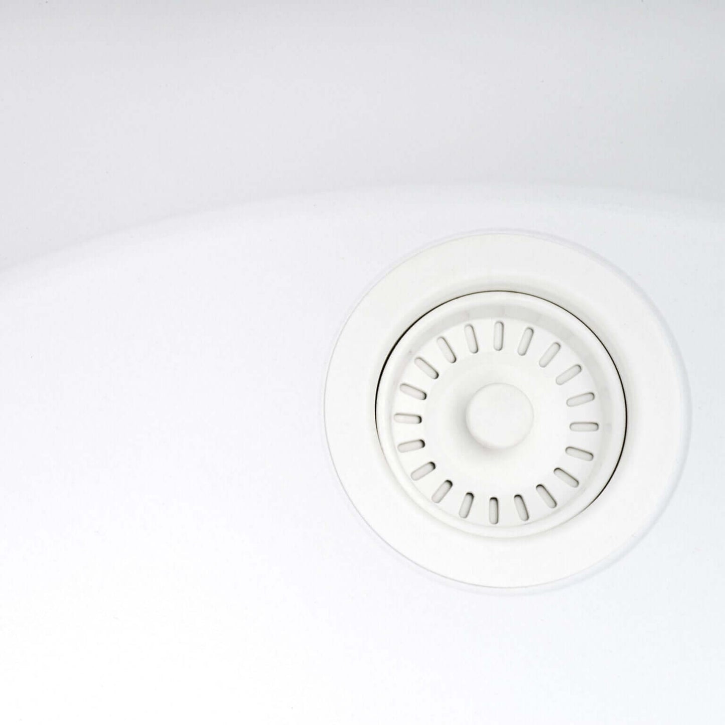 Close-up of a white kitchen sink drain in a Ruvati undermount sink.