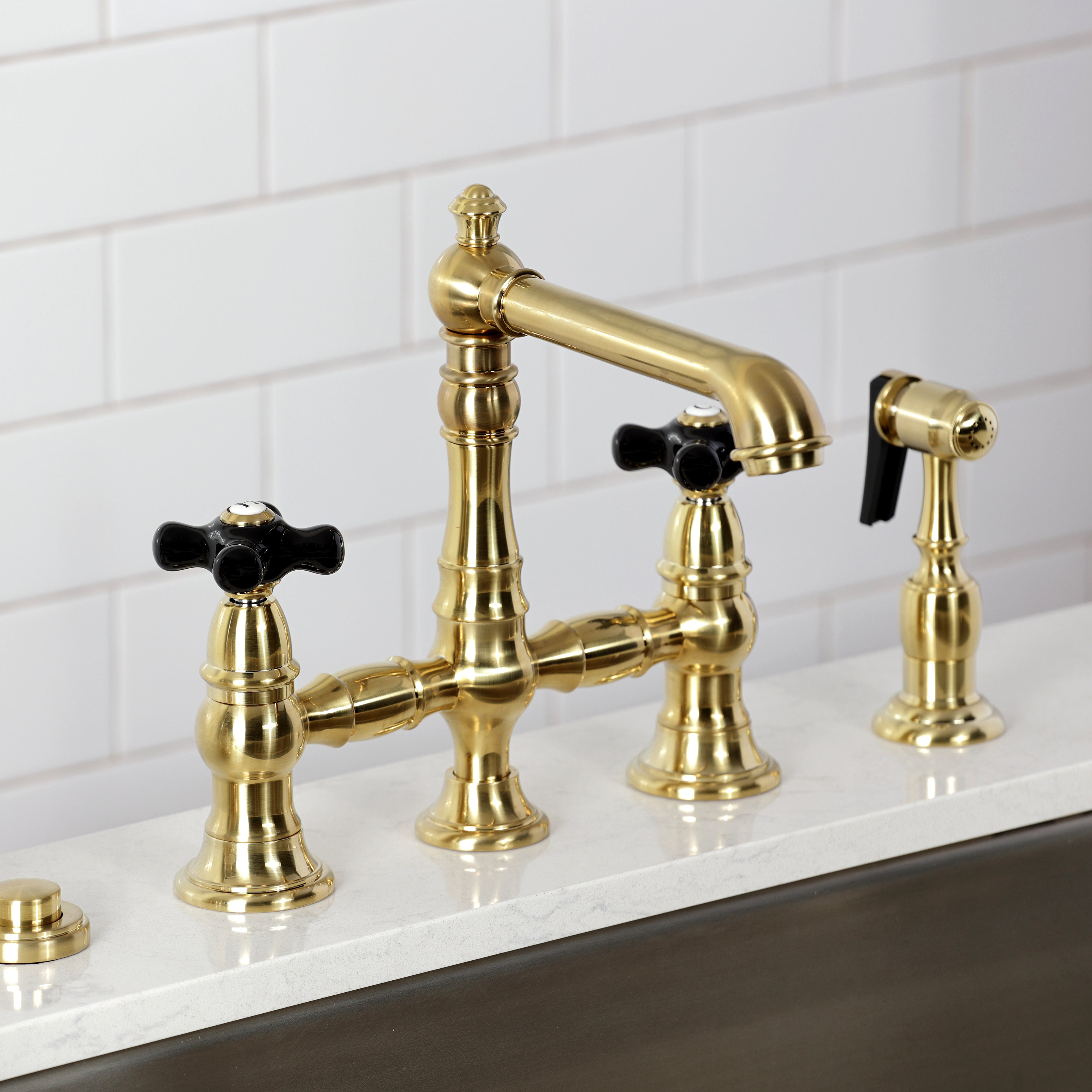 Kingston KS7277PKXBS Duchess Bridge Kitchen Faucet with Brass Sprayer, Brushed Brass on a kitchen countertop.