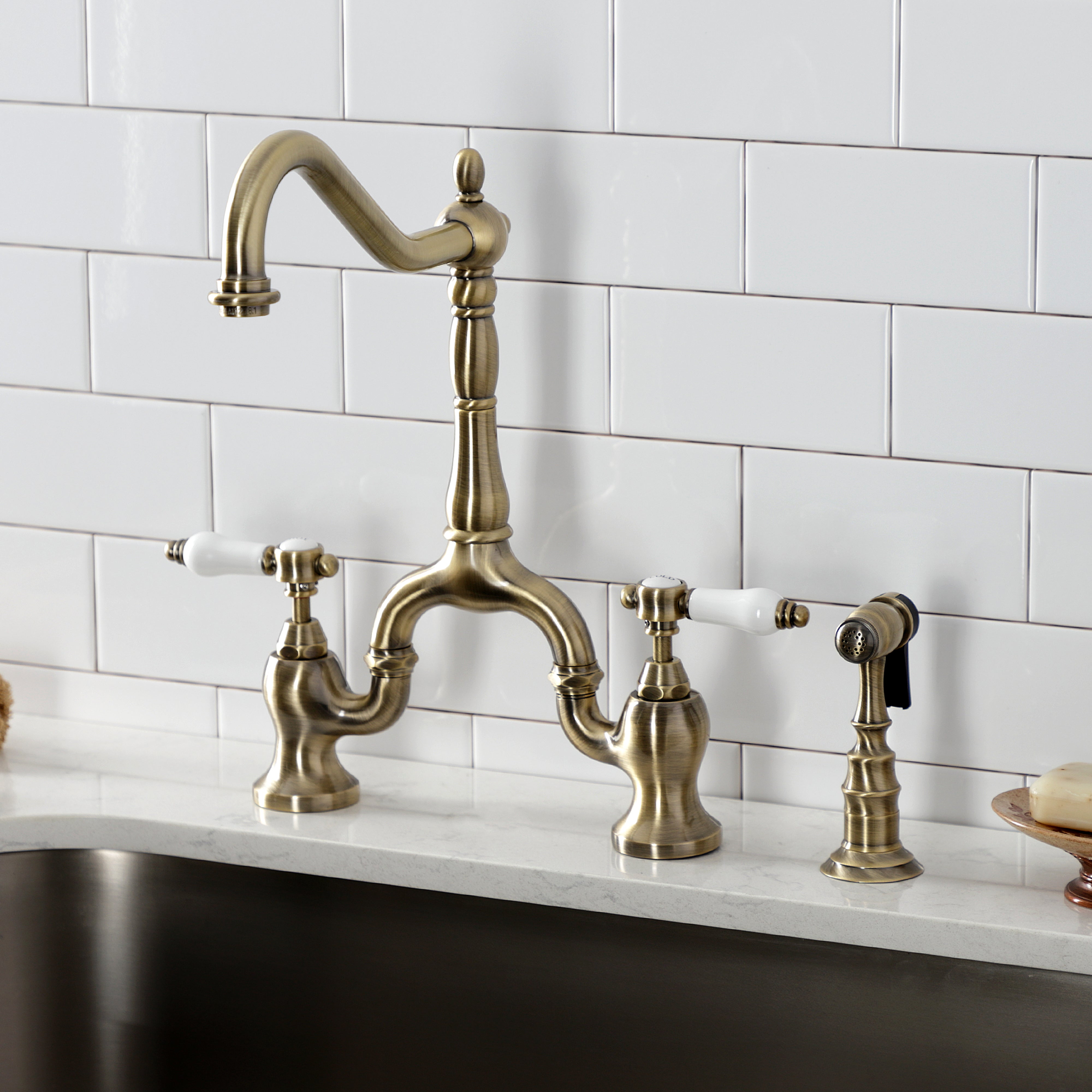 Kingston KS7753BPLBS Bel-Air Bridge Kitchen Faucet with Brass Sprayer, Antique Brass installed in kitchen.
