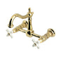 Kingston KS1263PX Heritage Two-Handle Wall Mount Bridge Kitchen Faucet, Antique Brass with swivel and white cross handles.