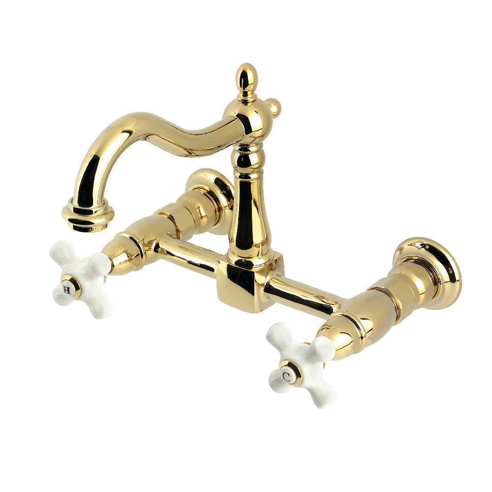 Kingston KS1263PX Heritage Two-Handle Wall Mount Bridge Kitchen Faucet, Antique Brass with swivel and white cross handles.