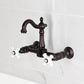 Kingston KS2443PX Heritage Two-Handle Wall Mount Bridge Kitchen Faucet, Antique Brass with Victorian spout and porcelain handles.