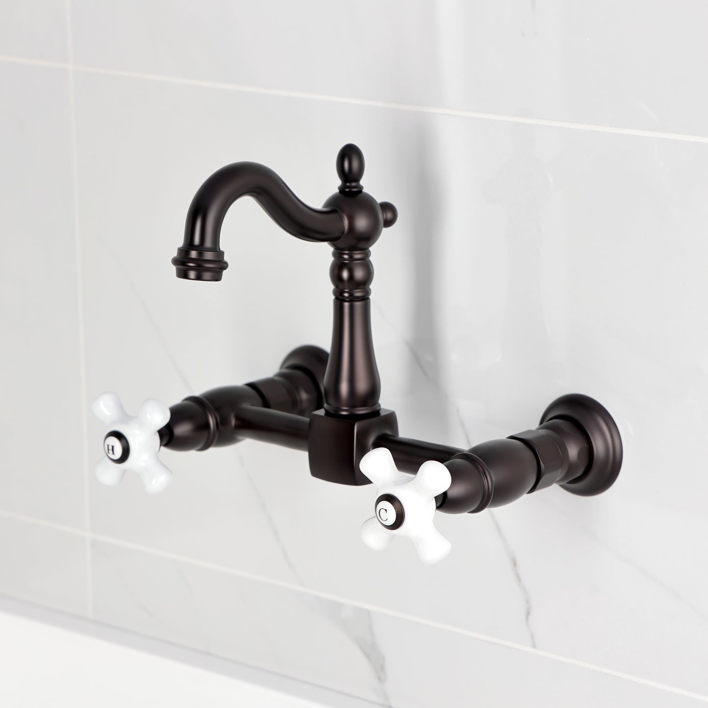 Kingston KS2443PX Heritage Two-Handle Wall Mount Bridge Kitchen Faucet, Antique Brass with Victorian spout and porcelain handles.