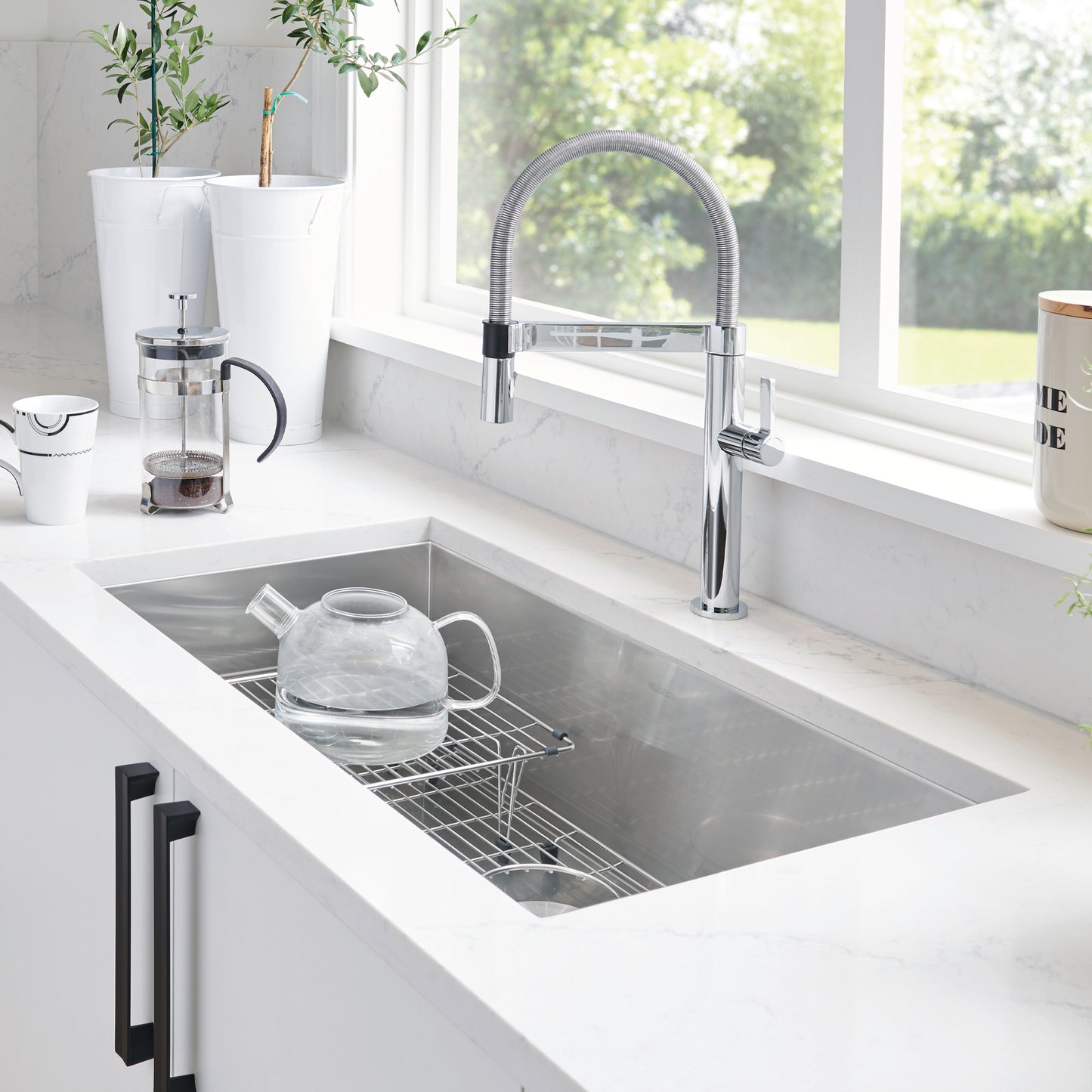 BLANCO Quatrus R0 32" Single Bowl Undermount Stainless Steel Kitchen Sink with modern faucet and glass kettle.