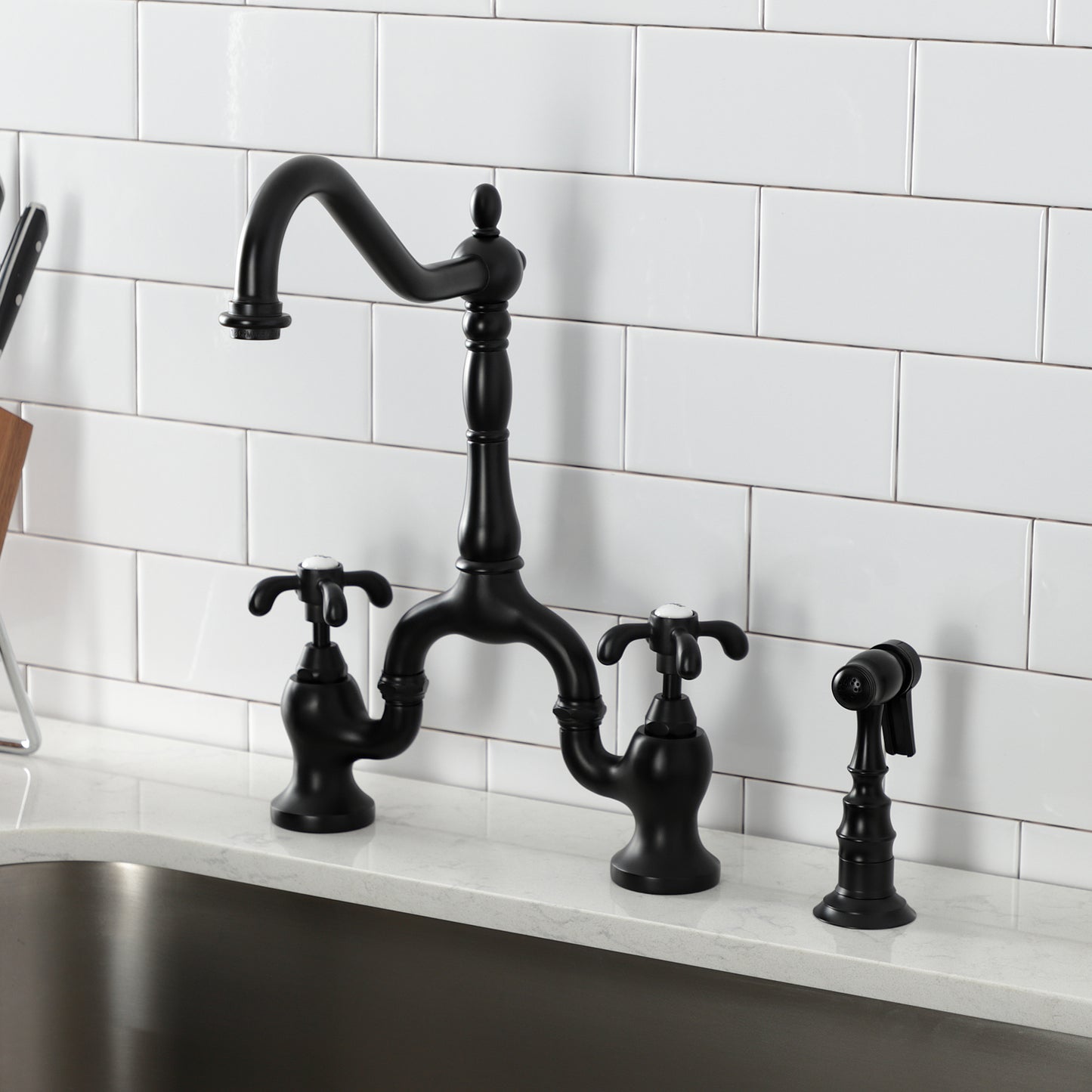 Kingston KS7753TXBS French Country Bridge Kitchen Faucet with Brass Sprayer, Antique Brass in sleek black finish.
